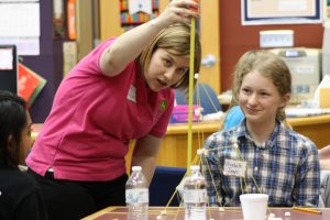 Middle school female demonstrates her STEM project.