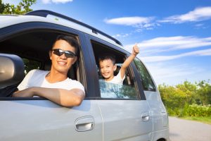 Happy little boy with father sitting in the car
