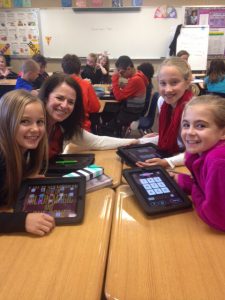 Summit teacher Nancy Ellis works with three female students to get their ipads set up.