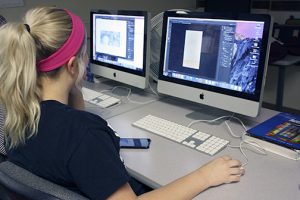 lauren Bellis in front of a computer working on a design project.