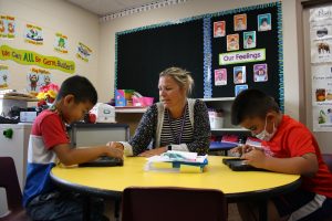 Camp Dragon 2021 teacher helping two students